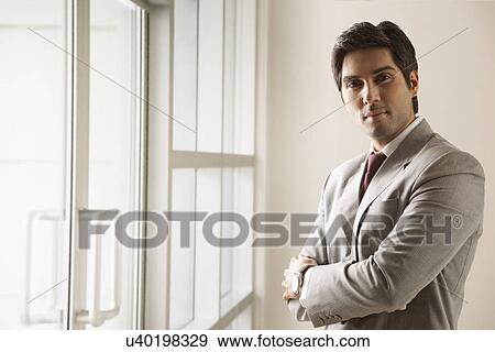 Portrait of business man standing with arms crossed View Large Photo Image Stock Photo - Portrait of business man standing with arms crossed . Fotosearch