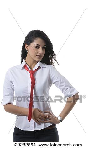 Portrait of confident fashionable businesswoman standing with hand on hip against white background View Large Photo Image Picture - Portrait of confident fashionable businesswoman standing with hand on hip against white background. Fotosearch
