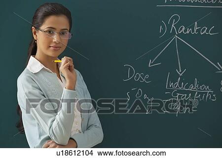 Portrait of confident female teacher against green board View Large Photo Image Picture - Portrait of confident female teacher against green board . Fotosearch