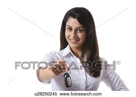 Portrait of confident saleswoman holding car keys against white background View Large Photo Image Stock Photography - Portrait of confident saleswoman holding car keys against white background. Fotosearch