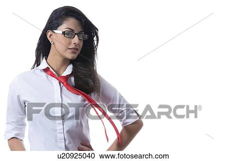 Stock Image - Portrait of confident stylish businesswoman with windswept tie against white background. Fotosearch