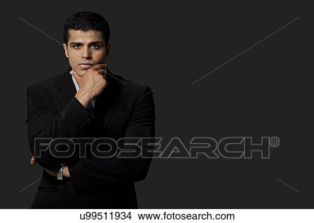 Portrait of confident young business man over black background View Large Photo Image Picture - Portrait of confident young business man over black background . Fotosearch