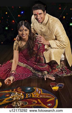 Stock Image - Portrait of couple in front of rangoli. Fotosearch