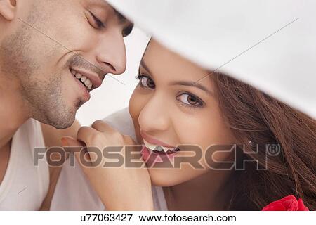 Stock Photo - Portrait of couple romancing in bed. Fotosearch