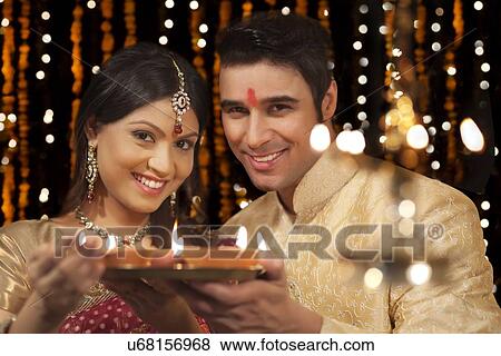 Stock Photo - Portrait of couple with tray of diyas. Fotosearch