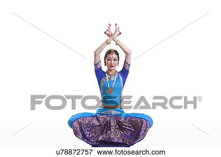 Stock Photo - Portrait of dancer with arms raised performing Bharatanatyam isolated over white background. Fotosearch
