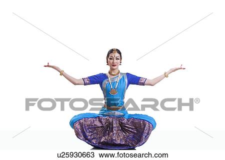 Portrait of dancer with arms outstretched performing Bharatanatyam against white background View Large Photo Image Stock Image - Portrait of dancer with arms outstretched performing Bharatanatyam against white background. Fotosearch