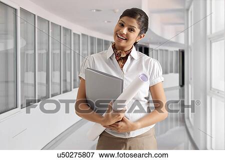 Portrait of elegant young businesswoman smiling with documents and paper View Large Photo Image Stock Photo - Portrait of elegant young businesswoman smiling with documents and paper . Fotosearch
