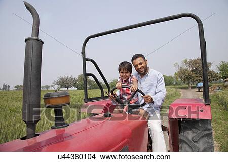 Picture - Portrait of father and son driving a tractor . Fotosearch