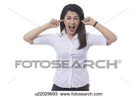 Portrait of frustrated businesswoman with fingers in ears screaming against white background View Large Photo Image Stock Image - Portrait of frustrated businesswoman with fingers in ears screaming against white background. Fotosearch