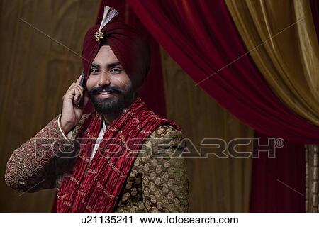 Stock Image - Portrait of groom having conversation on mobile phone . Fotosearch