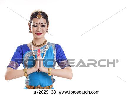 Stock Image - Portrait of happy Bharatanatyam dancer in prayer position over white background. Fotosearch