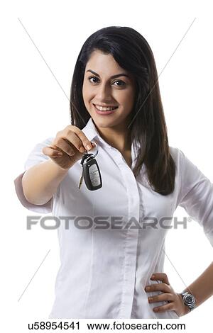 Portrait of happy businesswoman holding car keys against white background View Large Photo Image Stock Image - Portrait of happy businesswoman holding car keys against white background. Fotosearch