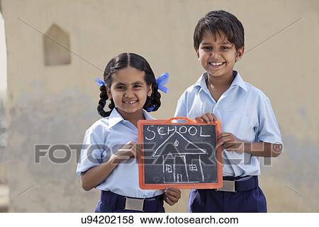 Portrait of happy children holding a slate View Large Photo Image Stock Photo - Portrait of happy children holding a slate . Fotosearch