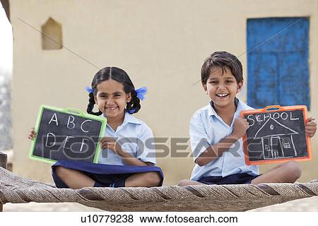 Portrait of happy children in school uniform holding a slate View Large Photo Image Stock Photo - Portrait of happy children in school uniform holding a slate . Fotosearch