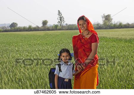 Portrait of happy daughter and mother standing together with field in background View Large Photo Image Stock Photography - Portrait of happy daughter and mother standing together with field in background . Fotosearch