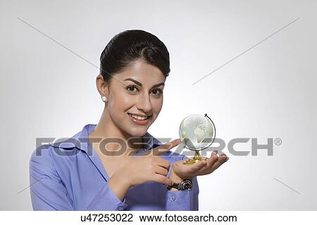 Portrait of happy Indian businesswoman holding crystal globe against gray background View Large Photo Image Stock Image - Portrait of happy Indian businesswoman holding crystal globe against gray background. Fotosearch