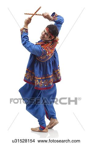 Portrait of happy young man in traditional clothes performing Dandiya Rass isolated over white background View Large Photo Image Picture - Portrait of happy young man in traditional clothes performing Dandiya Rass isolated over white background. Fotosearch