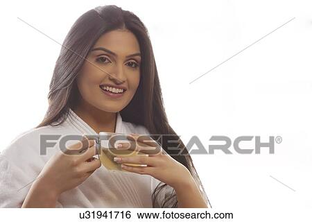 Portrait of happy young woman in bathrobe drinking tea View Large Photo Image Stock Photograph - Portrait of happy young woman in bathrobe drinking tea . Fotosearch