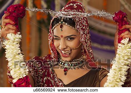 Picture - Portrait of Indian bride holding a garland . Fotosearch