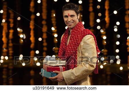 Portrait of man holding gifts View Large Photo Image Stock Photo - Portrait of man holding gifts. Fotosearch