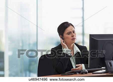 Portrait of mature businesswoman on call while looking at computer View Large Photo Image Stock Photograph - Portrait of mature businesswoman on call while looking at computer . Fotosearch