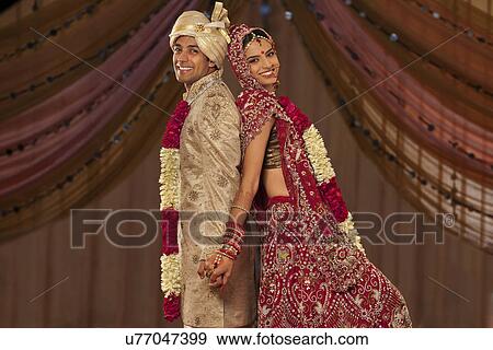 Portrait Of Newly Married Indian Couple Holding Hands Stock Photo