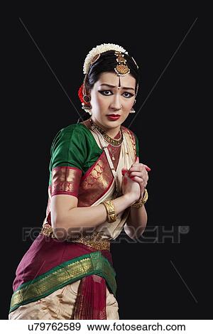 Stock Photo - Portrait of sacred Bharatanatyam dancer performing over black background. Fotosearch
