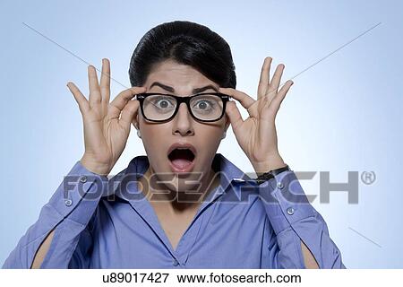 Portrait of shocked businesswoman wearing glasses against blue background View Large Photo Image Stock Photo - Portrait of shocked businesswoman wearing glasses against blue background. Fotosearch