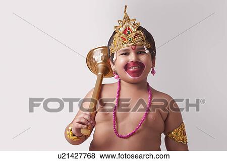 Stock Photo - Portrait of smiling boy dressed as God Hanuman against white background. Fotosearch