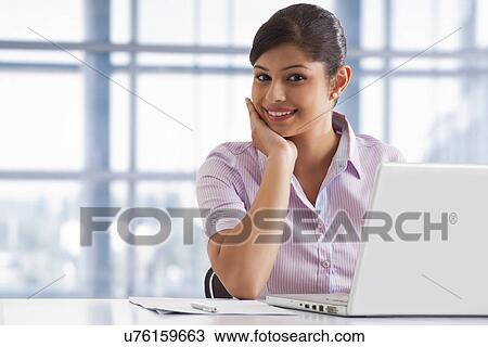 Portrait of smiling business woman at her desk with laptop View Large Photo Image Stock Image - Portrait of smiling business woman at her desk with laptop . Fotosearch