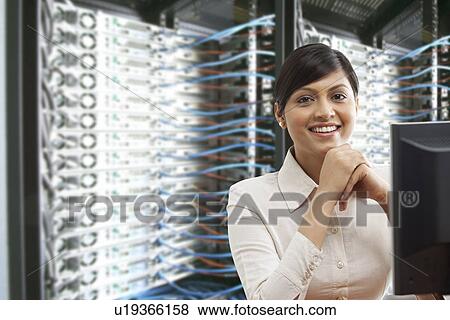 Portrait of smiling business woman sitting in server room View Large Photo Image Stock Photo - Portrait of smiling business woman sitting in server room . Fotosearch