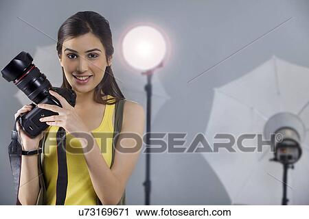 Portrait of smiling female photographer in front of spotlight in studio shot View Large Photo Image Stock Image - Portrait of smiling female photographer in front of spotlight in studio shot . Fotosearch