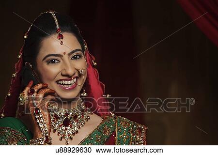 Stock Image - Portrait of smiling Indian bride talking on mobile phone . Fotosearch