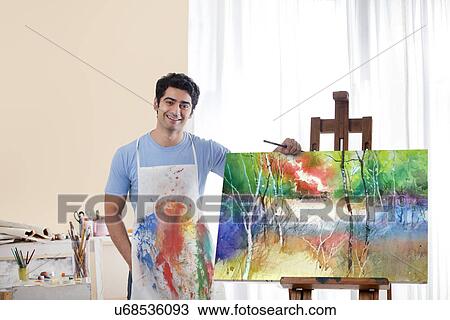 Portrait of smiling male painter standing by his painting View Large Photo Image Stock Image - Portrait of smiling male painter standing by his painting . Fotosearch