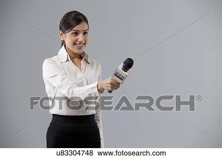 Portrait of smiling reporter holding out microphone View Large Photo Image Stock Photo - Portrait of smiling reporter holding out microphone . Fotosearch