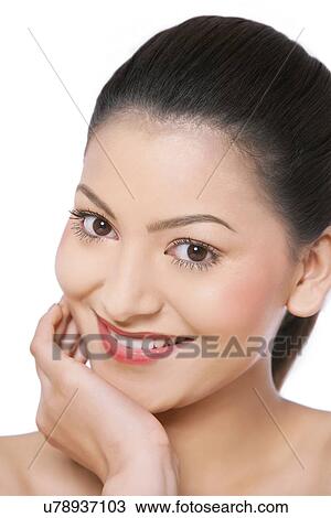 Stock Image - Portrait of smiling woman with hand on chin . Fotosearch