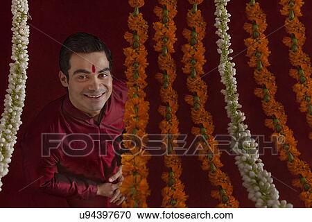 Portrait of smiling young bridegroom behind wreath View Large Photo Image Stock Image - Portrait of smiling young bridegroom behind wreath . Fotosearch