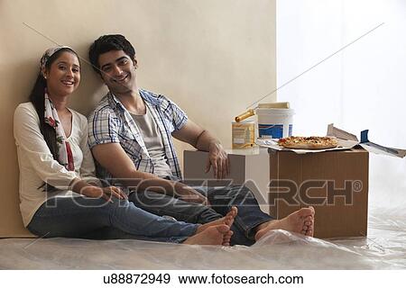 Stock Photo - Portrait of smiling young couple relaxing together at home . Fotosearch