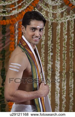 Portrait of smiling young groom wearing traditional Indian clothing View Large Photo Image Stock Photo - Portrait of smiling young groom wearing traditional Indian clothing . Fotosearch
