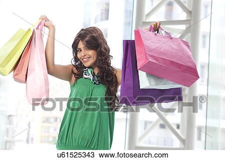 Portrait of smiling young woman with shopping bags View Large Photo Image Stock Image - Portrait of smiling young woman with shopping bags . Fotosearch