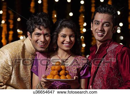 Portrait of two men and a woman holding sweets View Large Photo Image Stock Photo - Portrait of two men and a woman holding sweets. Fotosearch