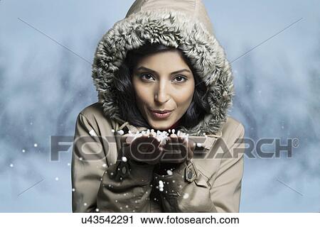 Portrait of woman blowing snow from her hands View Large Photo Image Stock Image - Portrait of woman blowing snow from her hands . Fotosearch