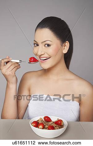 Portrait of woman eating cornflakes with strawberries View Large Photo Image Stock Image - Portrait of woman eating cornflakes with strawberries . Fotosearch