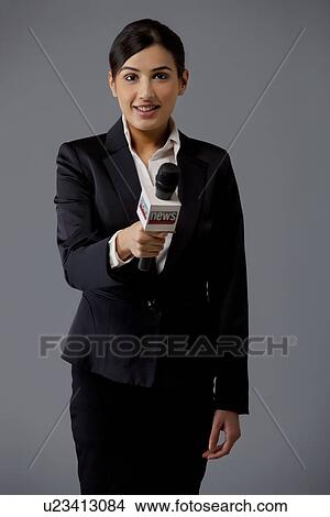 Portrait of woman news reporter holding out microphone against black background View Large Photo Image Picture - Portrait of woman news reporter holding out microphone against black background . Fotosearch