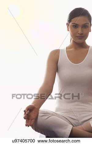 Stock Image - Portrait of woman sitting in lotus position. Fotosearch
