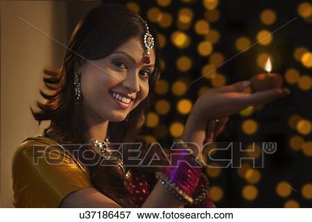 Stock Photo - Portrait of woman with a diya. Fotosearch