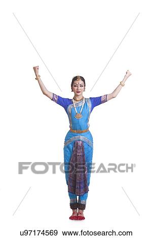 Portrait of woman with arms raised performing Bharatanatyam against white background View Large Photo Image Stock Photo - Portrait of woman with arms raised performing Bharatanatyam against white background. Fotosearch
