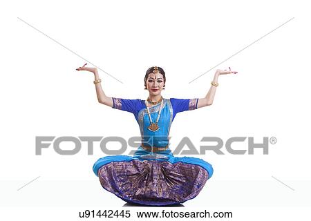 Stock Photography - Portrait of woman with arms raised performing Bharatanatyam isolated over white background. Fotosearch