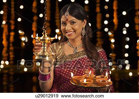 Stock Photo - Portrait of woman with tray of diyas. Fotosearch